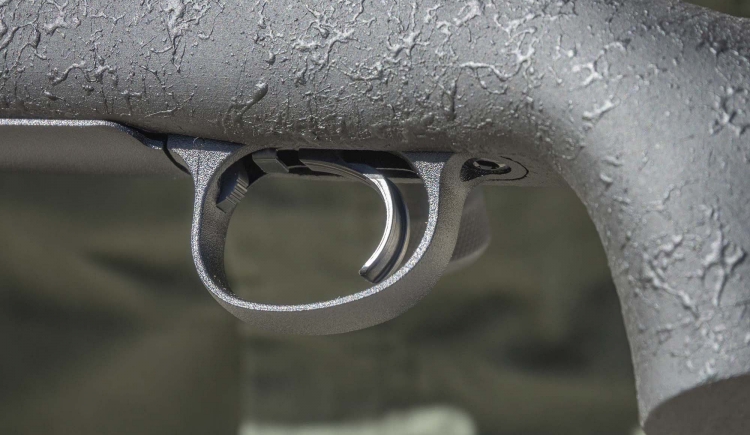 Di fronte al grilletto, all'interno della guardia, è visibile il pulsante di apertura dello sportello del caricatore