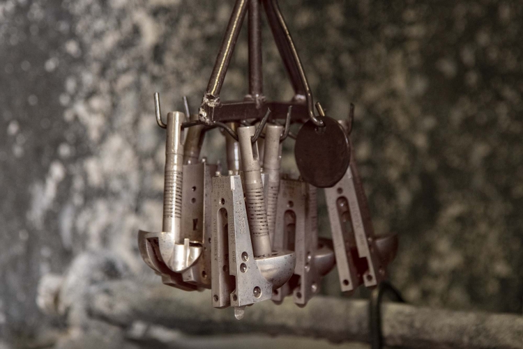 The parts to be treated are mounted on a support attached to a steel rod