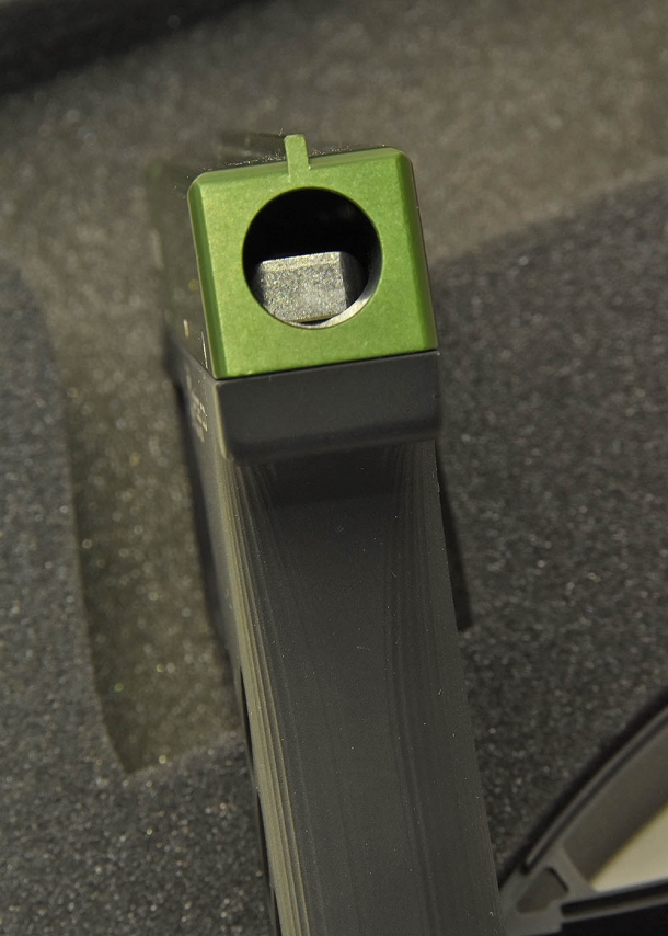 A close-up of the lever activated by the trigger that squeezes the canister within the device to release the spray