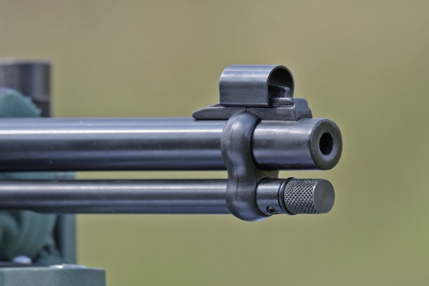 The front sight is protected inside a tunnel hood, which can be moved forward or backward