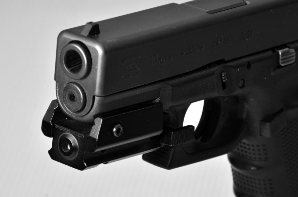 un laser applicato sulla slitta di una pistola Glock. questo accessorio non aumenta la precisione di chi non ha imparato a tirare correttamente il grilletto